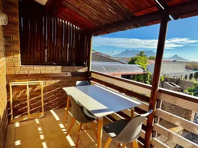 a table and chairs on a balcony with a view at Egret's Lookout in Cape Town