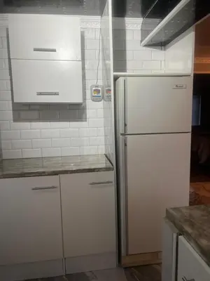 a kitchen with white cabinets and a refrigerator at Oryx guest house in Oakdale