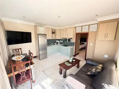 a living room with a couch and a kitchen at Clements Apartment in Avondale
