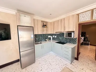 a kitchen with white cabinets and a stainless steel refrigerator at Clements Apartment in Avondale