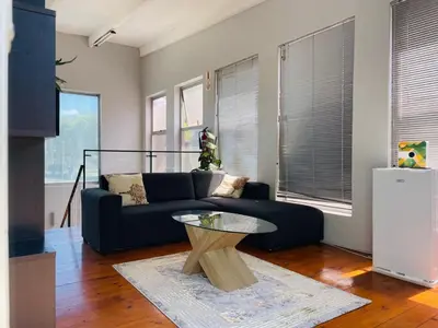 a living room with a couch and a table at claremont guesthouse in Cape Town