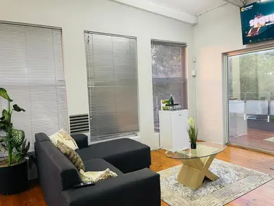 a living room with a couch and a table at claremont guesthouse in Cape Town