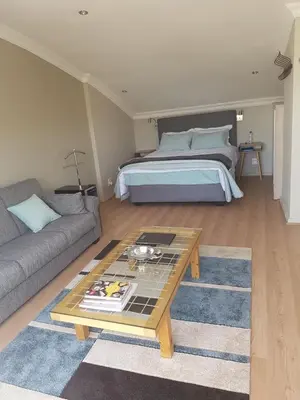 a living room with a bed and a coffee table at Tyger Waterfront Penthouse Duplex Apartment in Tyger Valley
