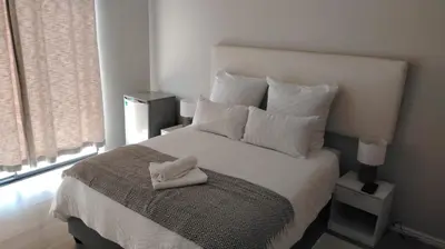 a bed with a white towel on top of it at Tin Home 88 in Cape Town