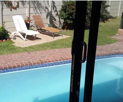 a view of a swimming pool with two chairs at Christal Villa A33 in Cape Town