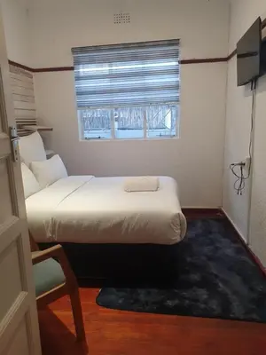 a small bedroom with two beds and a window at Ludinz Accomodation Self Catering in Avondale