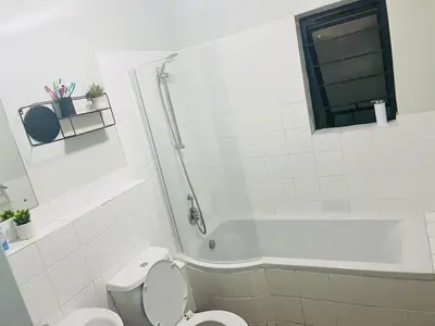 a bathroom with a shower and a toilet and a tub at Valley Escape in Cape Town