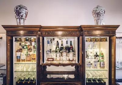 a refrigerator filled with lots of bottles and alcohol at Oude Werf Hotel in Stellenbosch