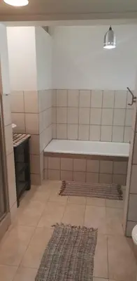 a bathroom with a tub and a rug at Pennywhistle in Eersterivier