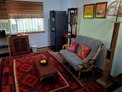 a living room with a chair and a table at Pennywhistle in Eersterivier