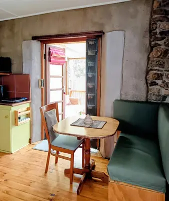 a dining room with a table and a chair at Serene, cosy stay with a mountain view in Greyton