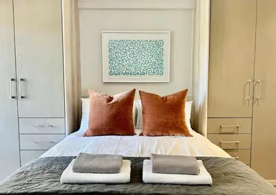 a bedroom with a bed with two pillows on it at 22 at The Den in Stellenbosch
