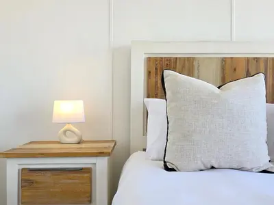 a bedroom with a white bed with a wooden headboard at Sea, Canal & Mountain View, Rooftop Jacuzzi & BBQ in Cape Town