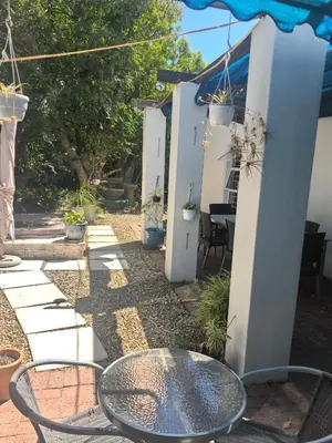 a patio with a table and chairs in a yard at 22 on breezand in Cape Town