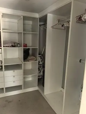 a walk in closet with white cabinets and shelves at 22 on breezand in Cape Town