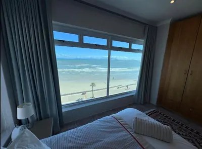 a bedroom with a large window with a view of the beach at Pips Place Penthouse 501 in Strand