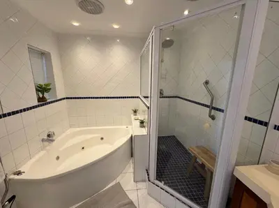 a white bathroom with a tub and a shower at Pips Place Penthouse 501 in Strand