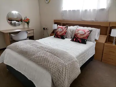 a bedroom with a bed and a desk and a mirror at Mimosa House Double Room in Brackenfell