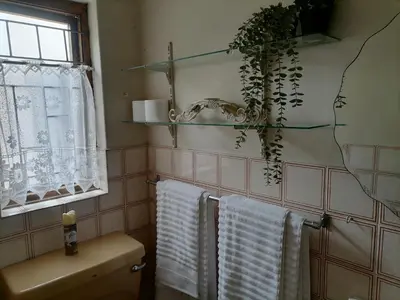 a bathroom with white towels hanging on a rack at Mimosa House Double Room in Brackenfell