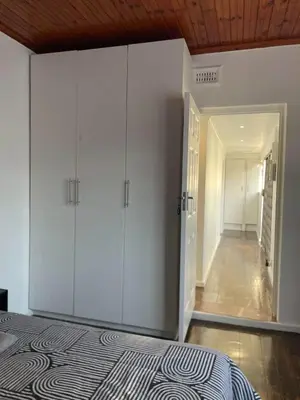 a bedroom with white cabinets and a hallway at AAA Luxury Homes Goodwood Cpt in Elsiesrivier