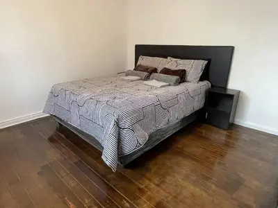 a bed in a bedroom with a wooden floor at AAA Luxury Homes Goodwood Cpt in Elsiesrivier