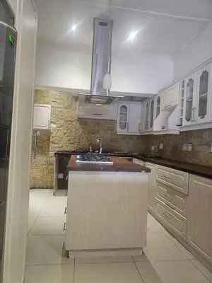 a kitchen with white cabinets and a island in it at Ludinz Self Catering Accommodation in Avondale