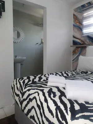 a zebra print bed in a room with a bathroom at Ludinz Self Catering Accommodation in Avondale