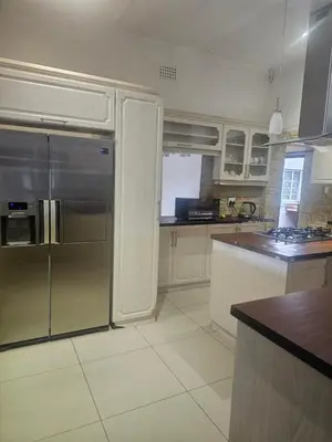 a kitchen with a stainless steel refrigerator and a counter at Ludinz Self Catering Accommodation in Avondale