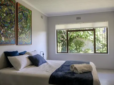 a bedroom with a large bed with a window at House Nico in Hermanus