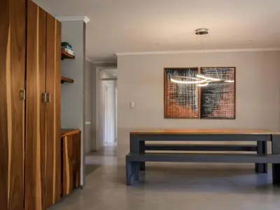a dining room with a bench and a chandelier at House Nico in Hermanus
