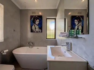 a bathroom with a white tub and a sink at House Nico in Hermanus