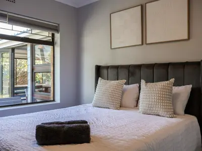 a bedroom with a bed with a large window at House Nico in Hermanus