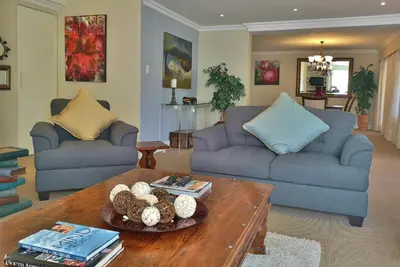 a living room with two blue couches and a coffee table at Val d'Or Estate in Franschhoek
