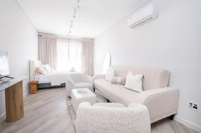 a white living room with a couch and chairs at 232 Paarl Studio With AC and Onsite Parking in Paarl