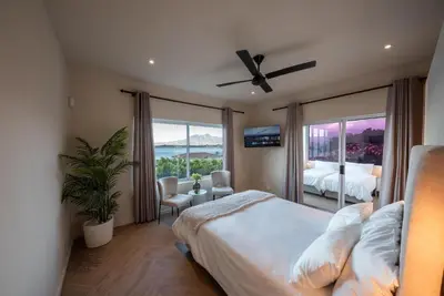 a bedroom with a bed and a window with a view at Villa Solara, 6 bedroom Vacation Villa with sea view in Gordonʼs Bay