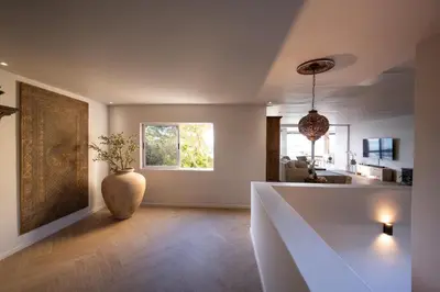 a living room with a vase sitting on the floor at Villa Solara, 6 bedroom Vacation Villa with sea view in Gordonʼs Bay