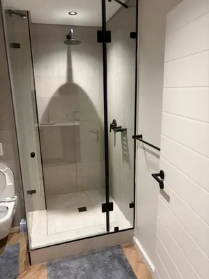 a glass shower stall in a bathroom with a toilet at Urban Ridge in Cape Town