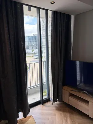 a living room with a large window and a television at Urban Ridge in Cape Town