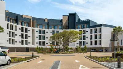 a large white building with a parking lot at Urban Ridge in Cape Town