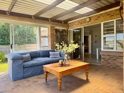 a living room with a blue couch and a coffee table at Sunset View in Durbanville