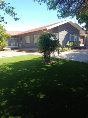 a house with a tree in the middle of a yard at Oakway Guest House 2 in Kuilsrivier