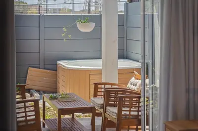 a balcony with a tub and a table and chairs at Lloyd's Corner in Cape Town