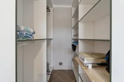 a closet with white cabinets and a bed in it at Lloyd's Corner in Cape Town
