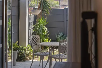a table and chairs on a balcony with a table and chairs at Lloyd's Corner in Cape Town