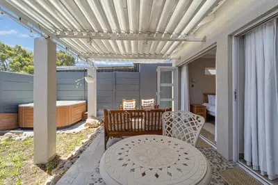 a patio with a table and a pergola at Lloyd's Corner in Cape Town
