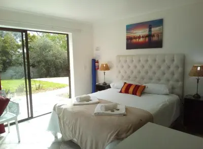 a bedroom with two beds and a large window at ABC GUEST HOUSEs BELLEVILLE in Bellville
