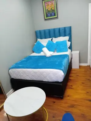 a bedroom with a bed with blue and white pillows at ABC GUEST HOUSEs BELLEVILLE in Bellville
