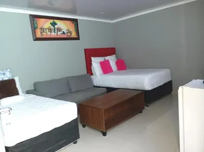 a room with two beds and a couch and a bed and a couch at ABC GUEST HOUSEs BELLEVILLE in Bellville
