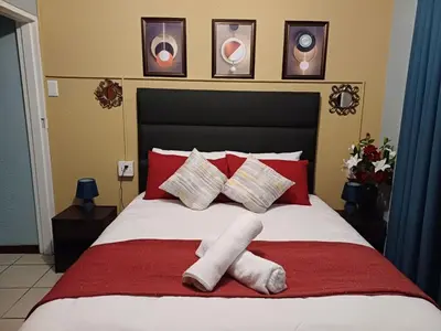 a bedroom with a bed with two towels on it at OakwayGuestSuit2 Private 1 Bed Kitchen Bath Aircon in Kuilsrivier