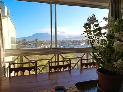 a view of a balcony with a table and chairs at Windy Corner Luxury Apartment in Gordonʼs Bay